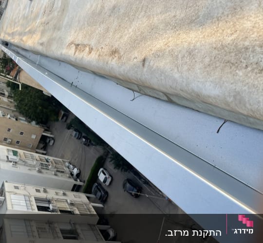 גג עם יריעת בידוד ומעקה מתכת
